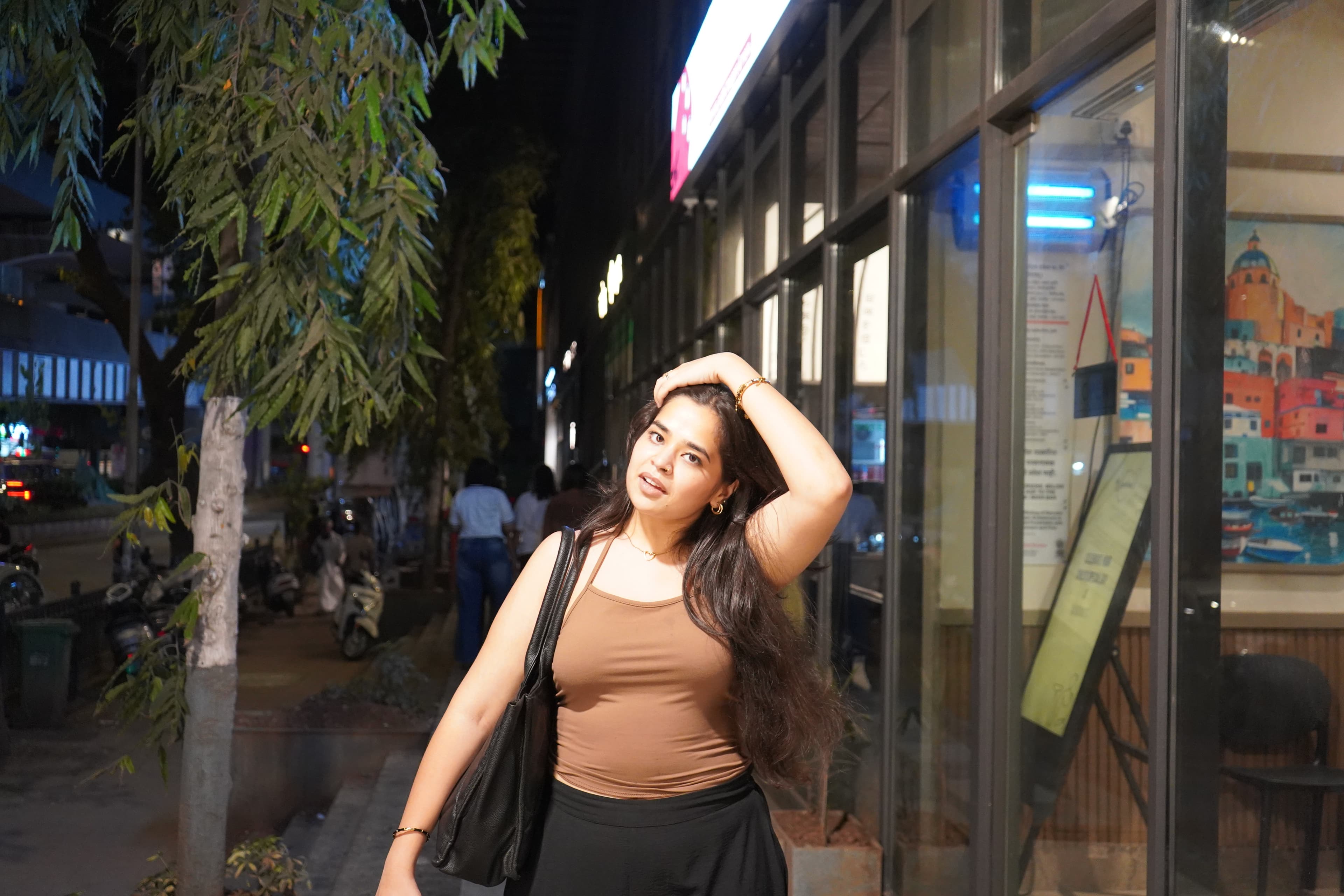 A companion standing outside a cafe in the evening