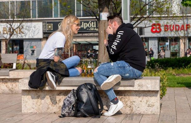 Two people catching up in a busy, open city square